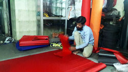 factory worker cutting material for making bags